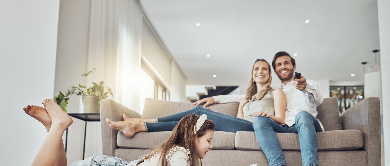 Happy family, relax or child on tablet in living room, house or home live streaming, movies channel or internet show bonding. Smile, parents or kid girl on technology, television or watching tv media.